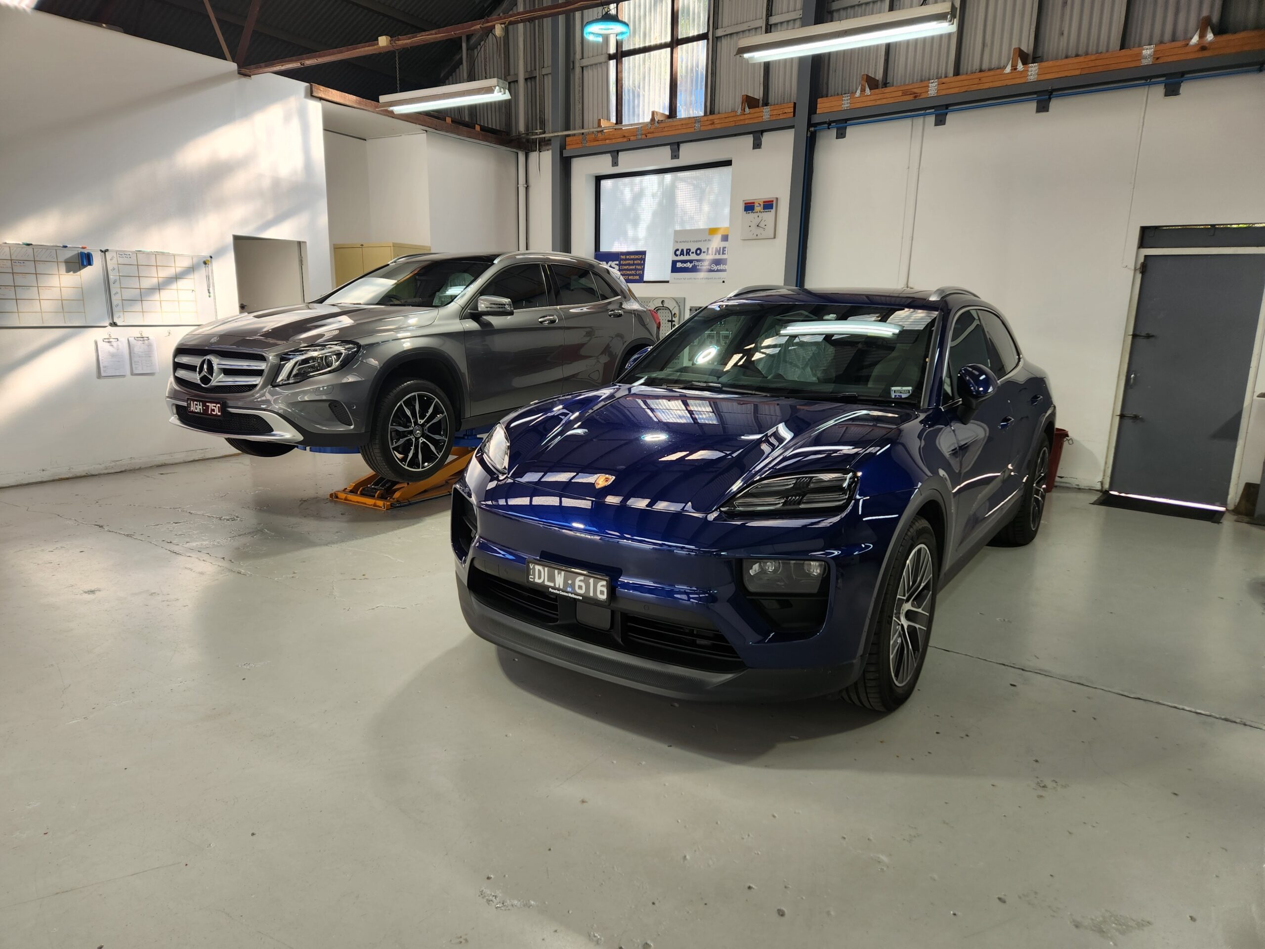 Blue Porsche Macan and Mercedes-Benz GLA inside after repair